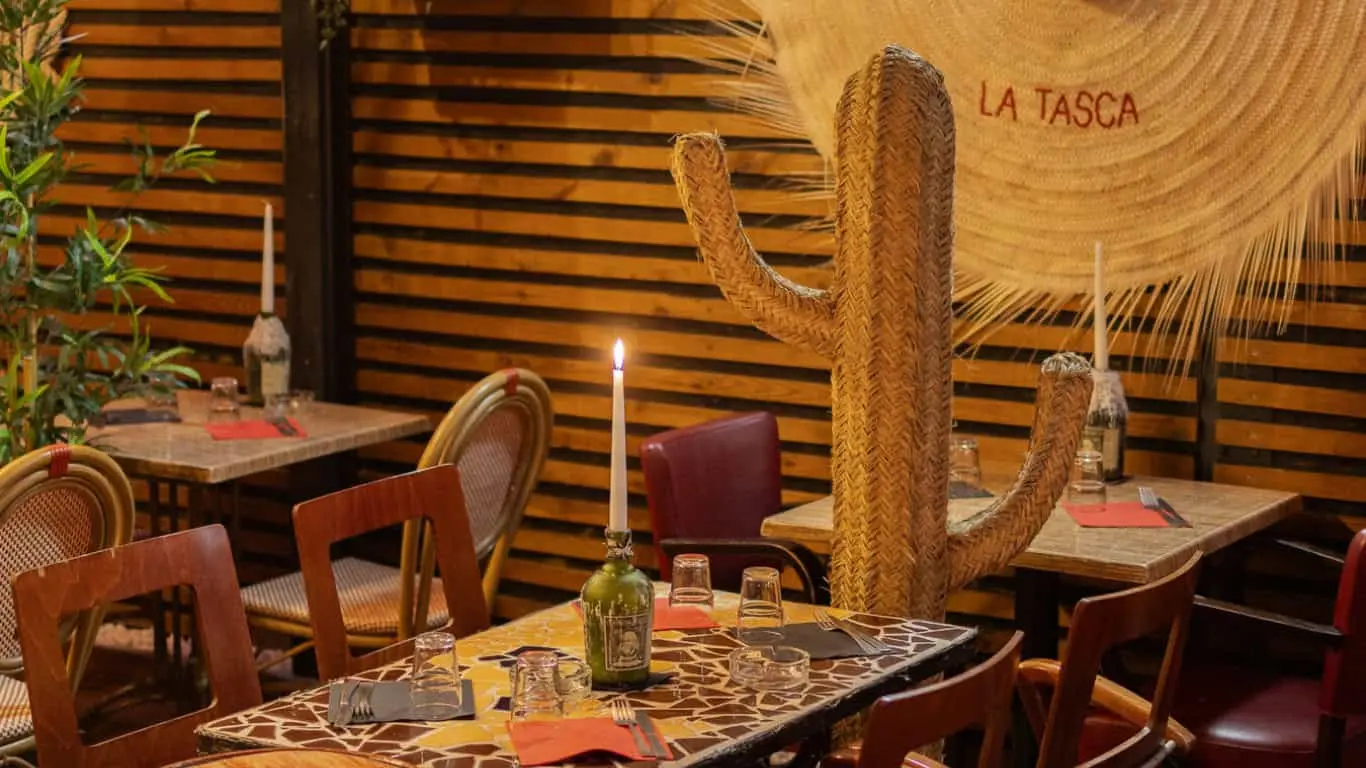 Salle de La Tasca avec cactus en paille, bougies et chaises en rotin